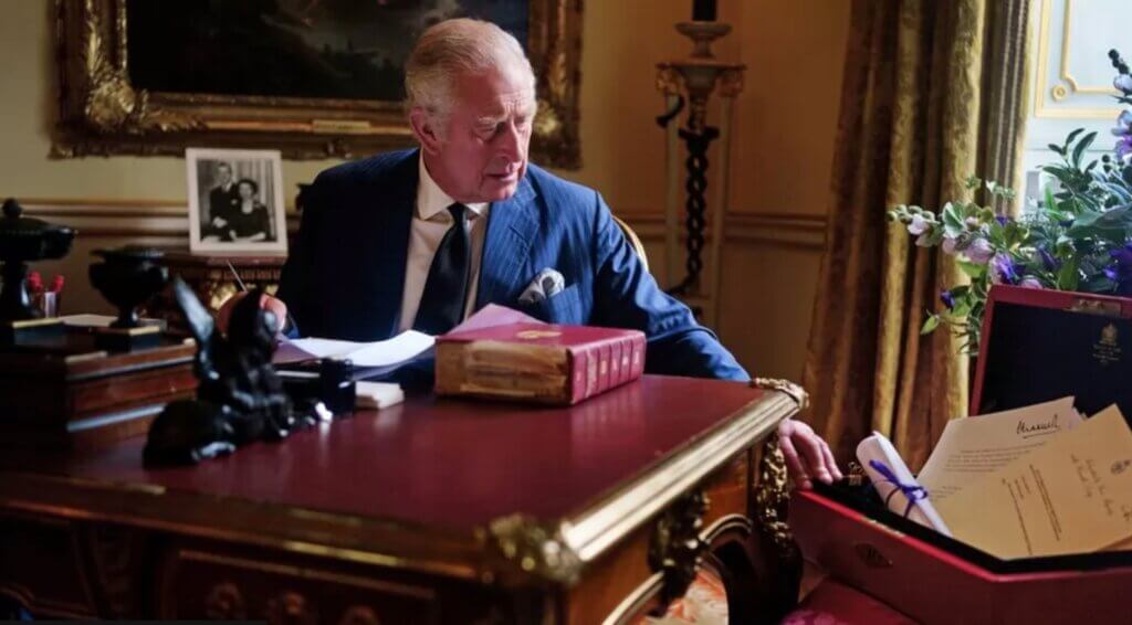 King Charles sitting on his desk
