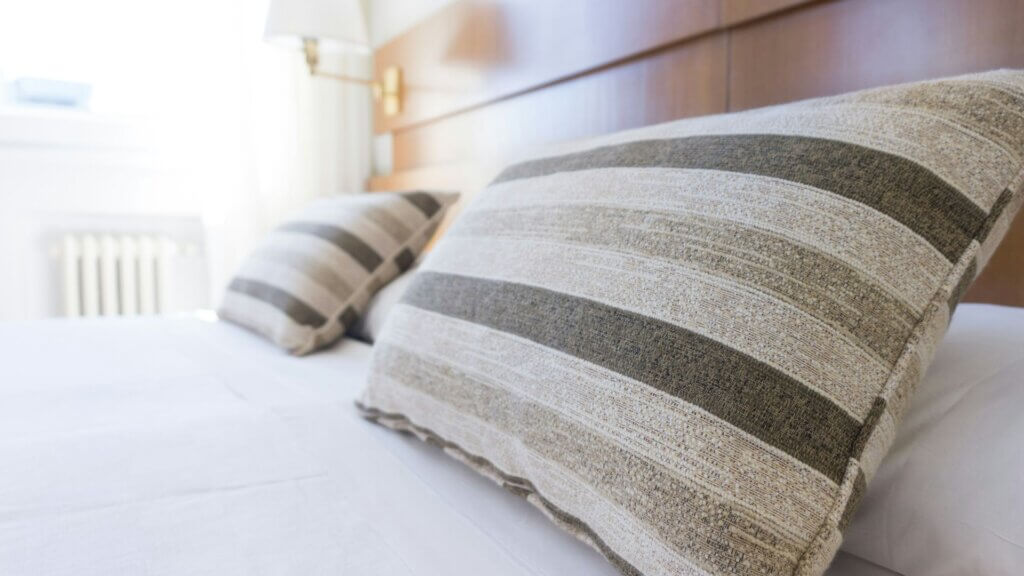 Gray and black throw pillows arranged neatly on a made bed in a cozy bedroom