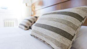 Gray and black throw pillows arranged neatly on a made bed in a cozy bedroom