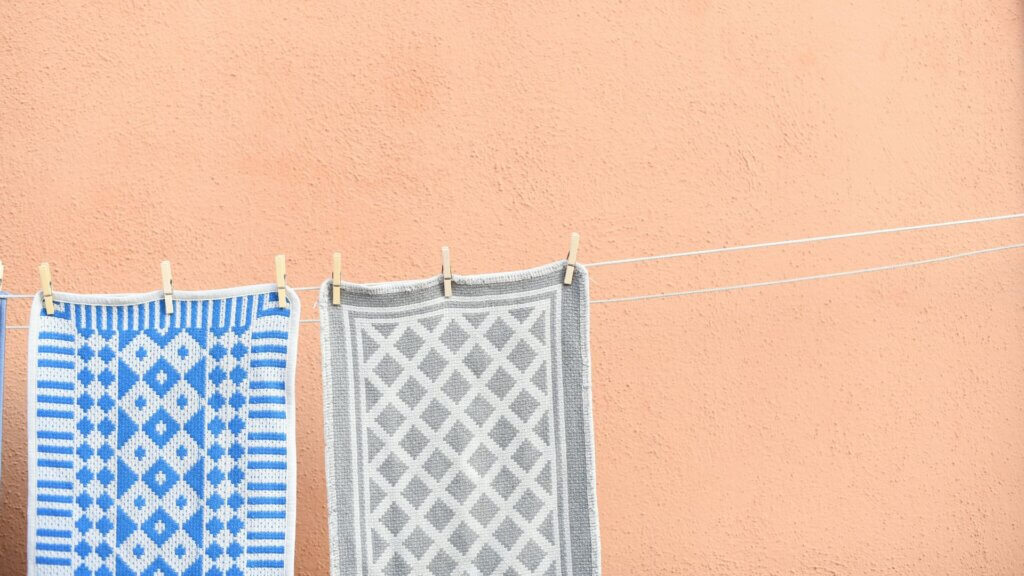 Colorful carpets hanging outside on strings to dry in the sun