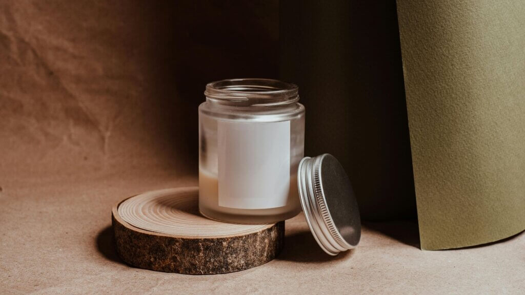 Jar with silver lid sitting on a wooden coaster on a table