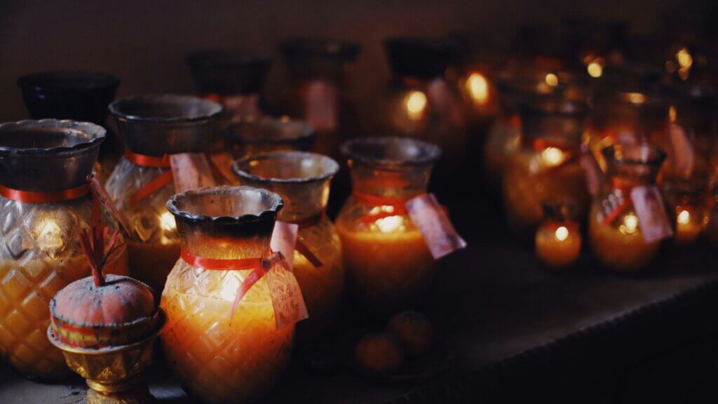 Table filled with ceramic vases and jars holding candles