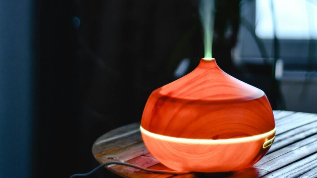 Wooden diffuser emitting mist on a table