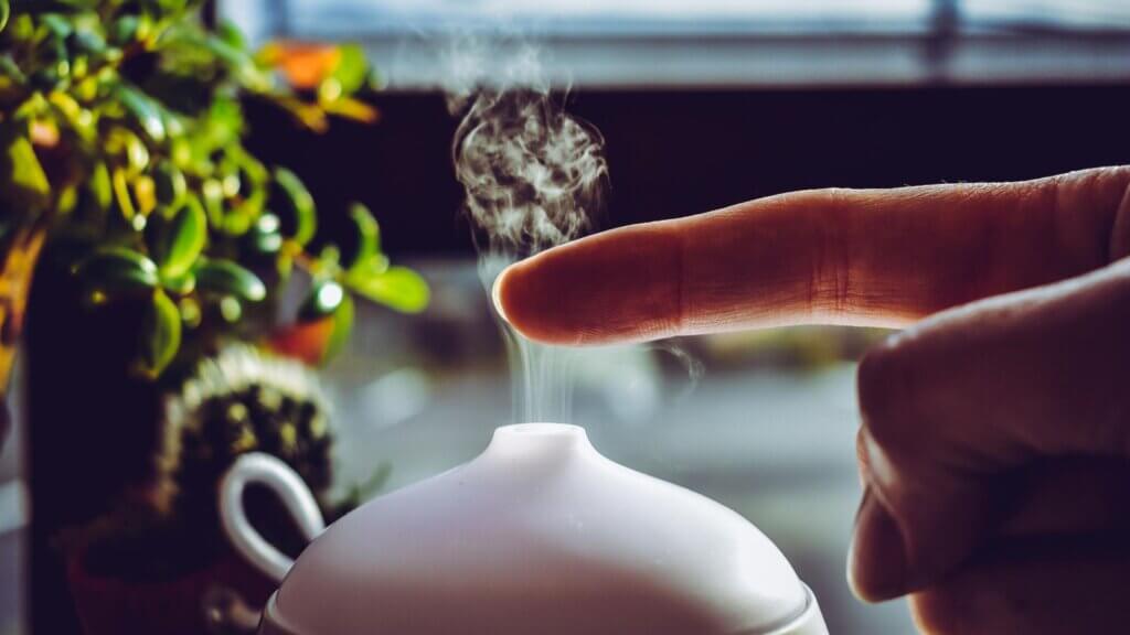 Person touching mist rising from a humidifier or diffuser