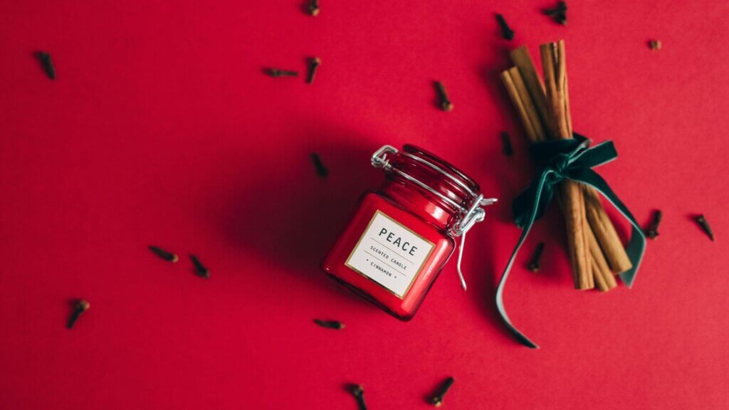 Candle inside a glass jar with dried flowers on top