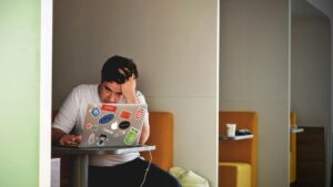 Man in white shirt using a MacBook Pro at a desk