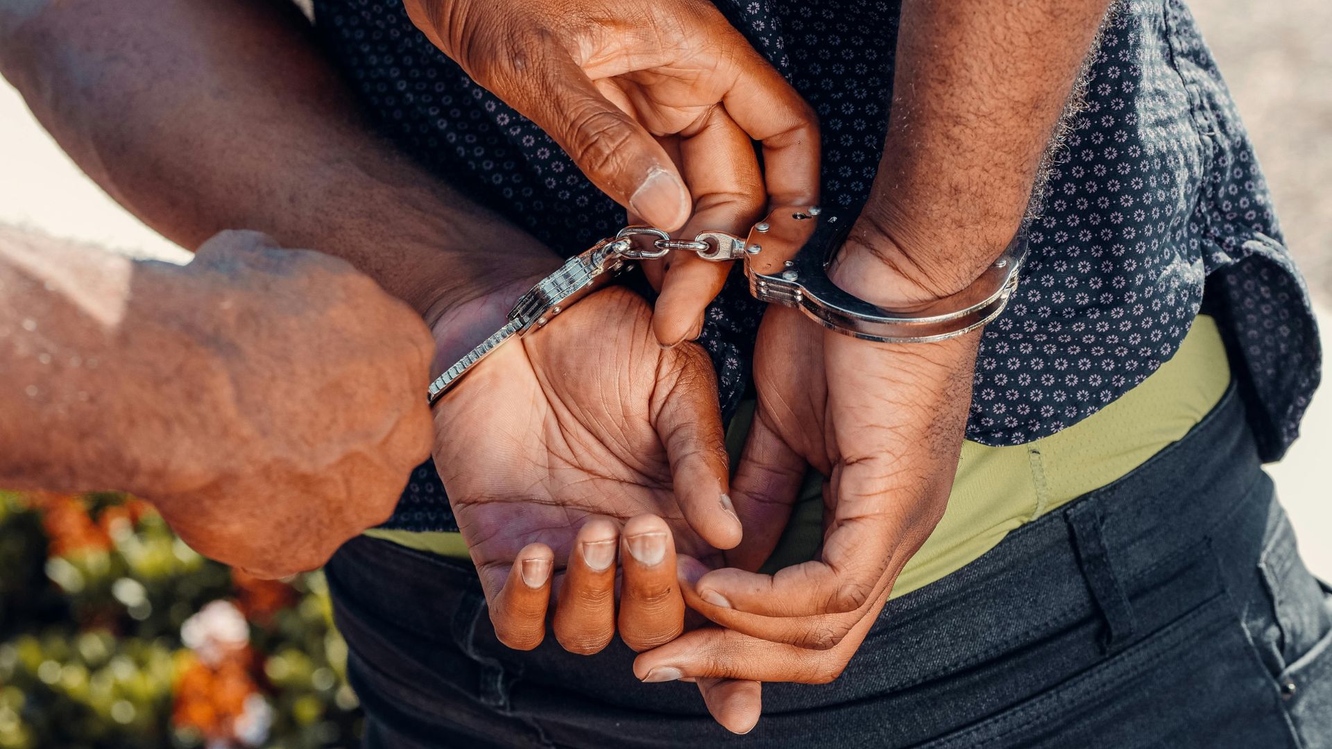 Person in black denim jeans holding a silver bracelet
