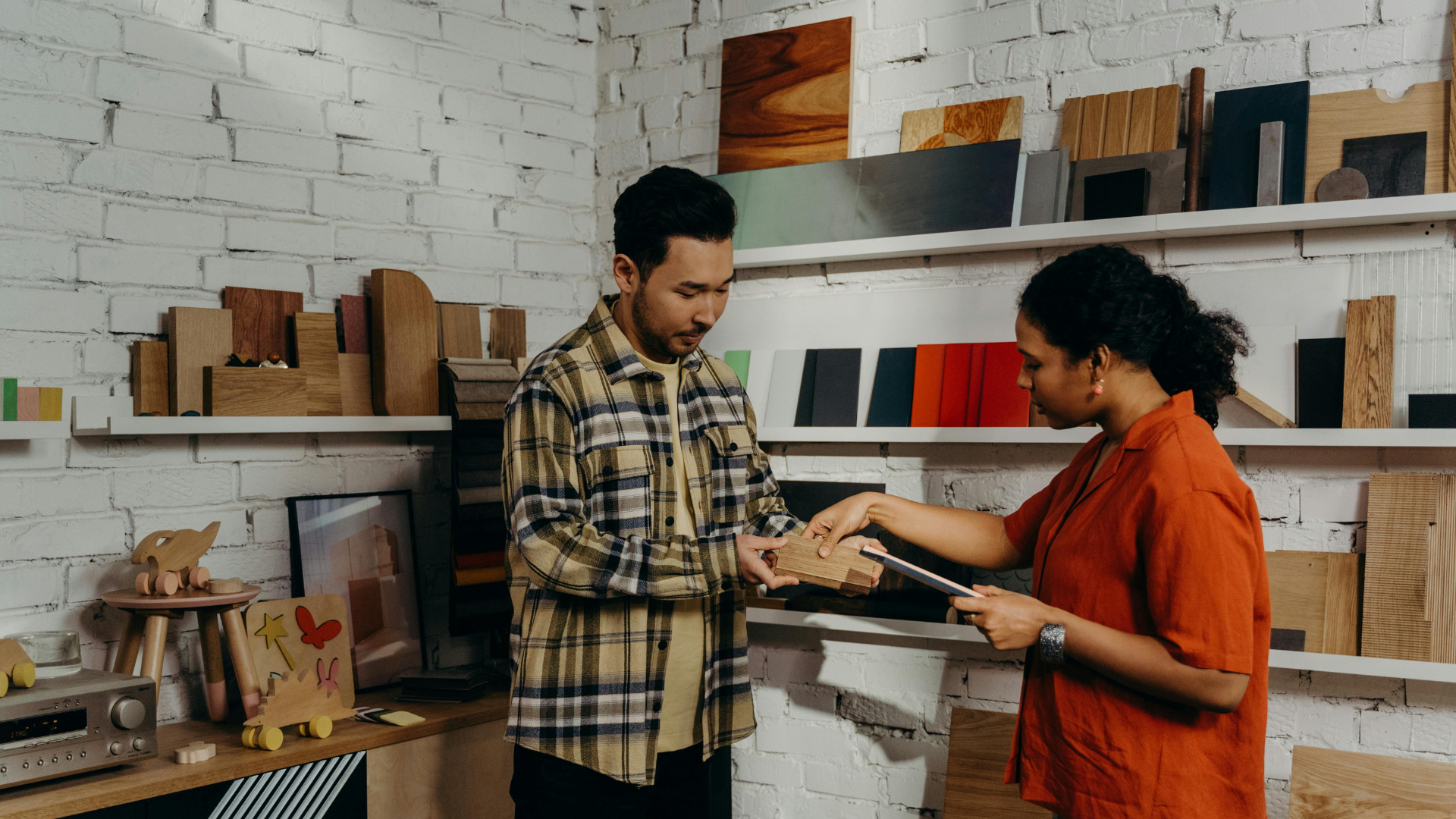 Man showing wood sample to woman during furniture shopping