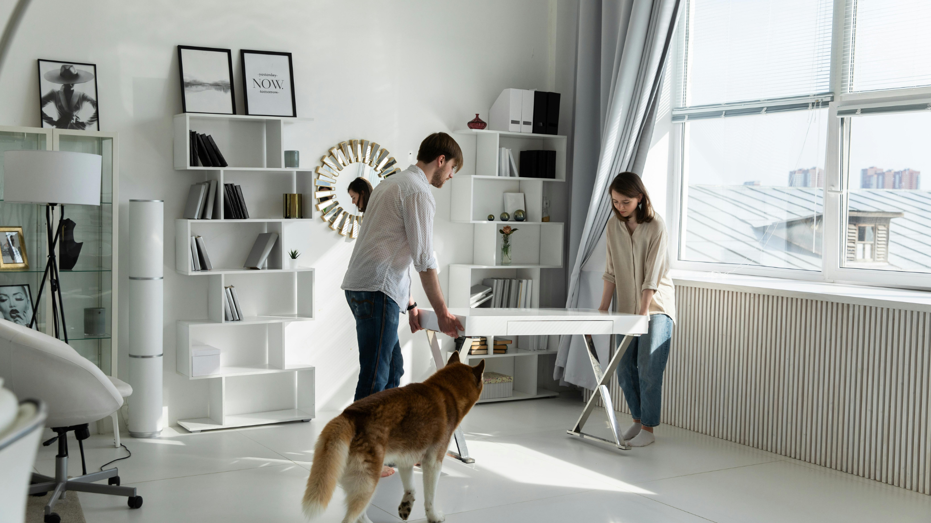 Couple moving white desk into room together
