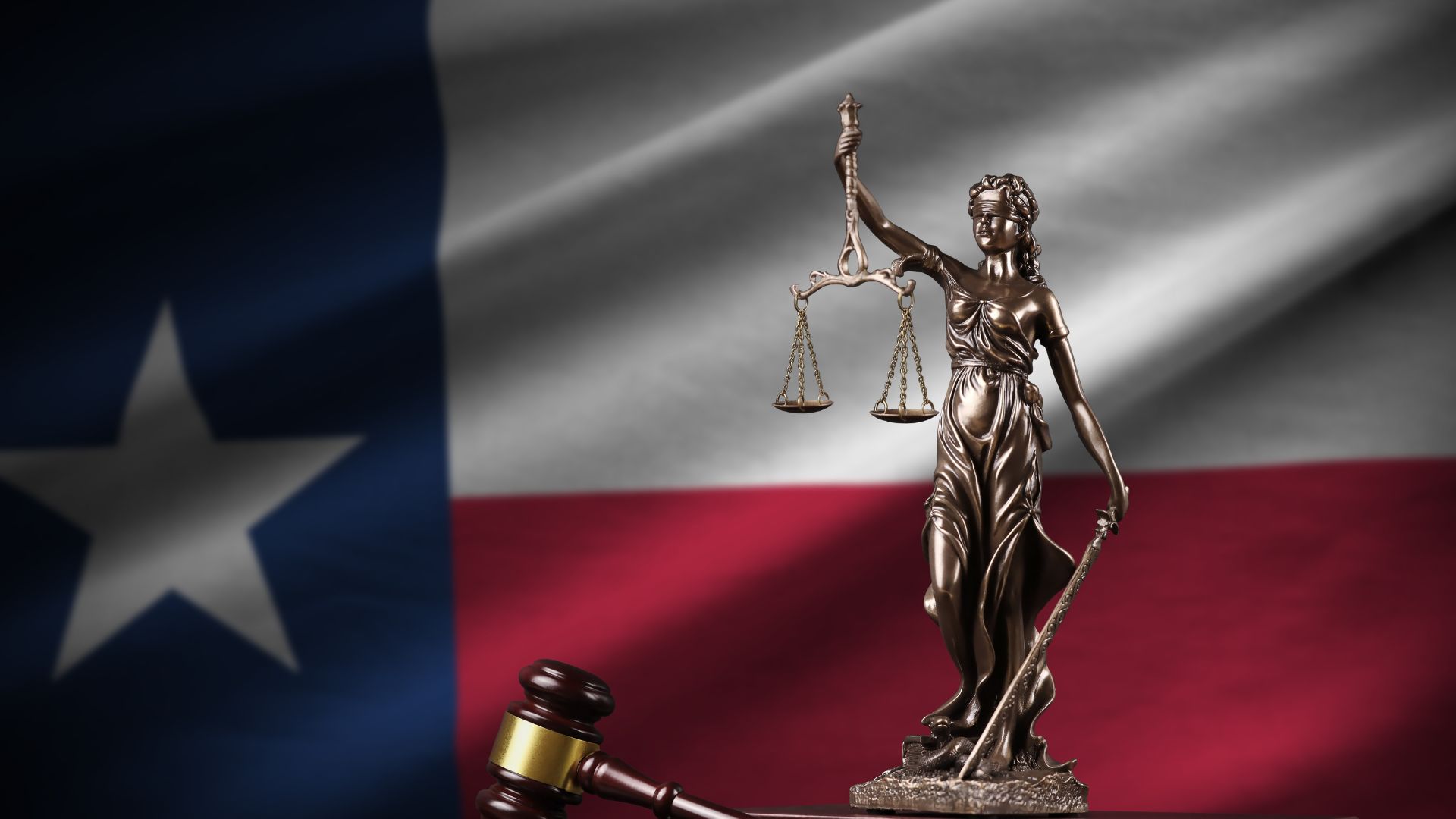 Texas state flag with the Statue of Lady Justice in front