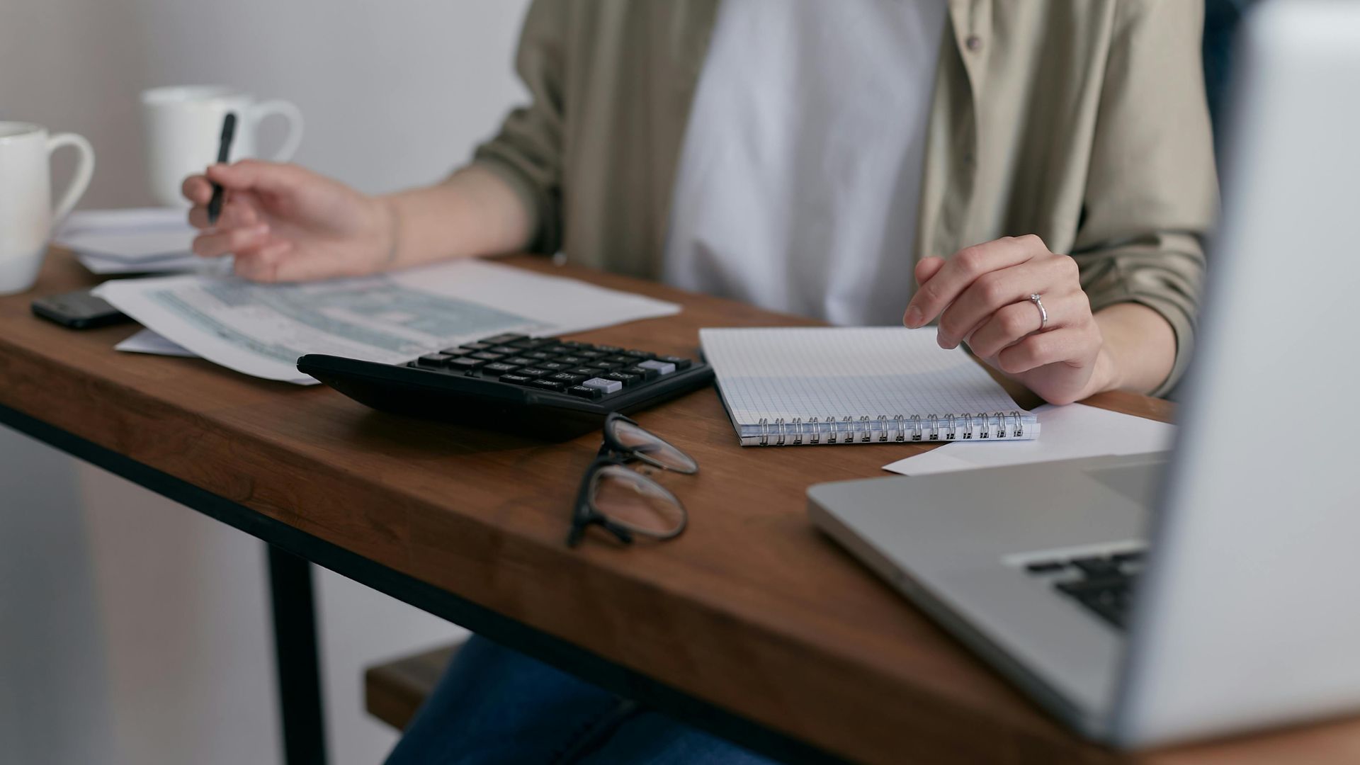 Two women sitting at a desk discussing paperwork