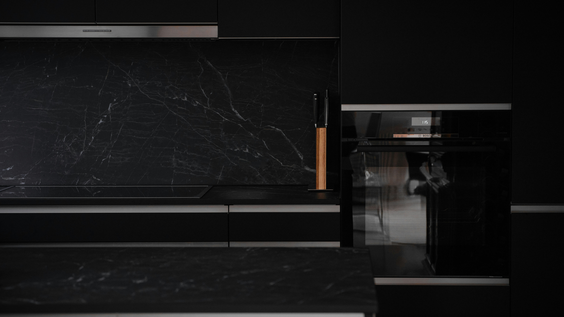 lack kitchen island with marble countertop and minimalist lighting