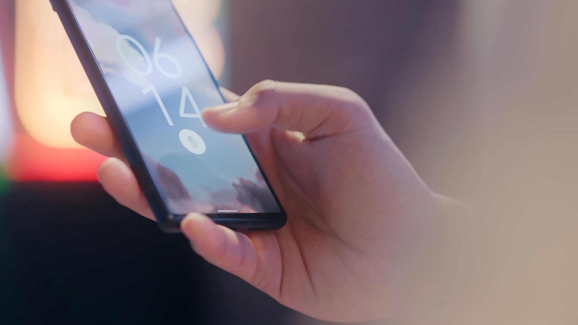 Person holding a mobile phone with login screen displayed