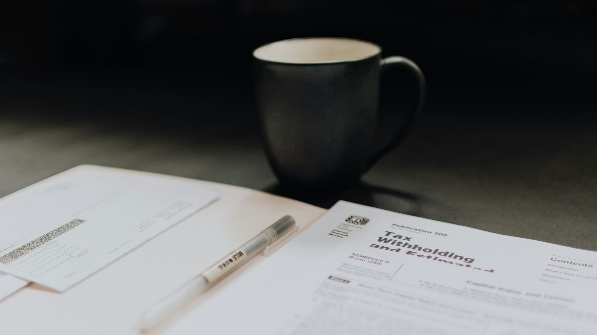 Coffee mug next to open folder with tax withholding document
