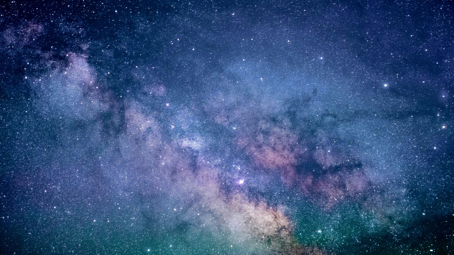 Digital wallpaper of a blue and purple galaxy with glowing stars