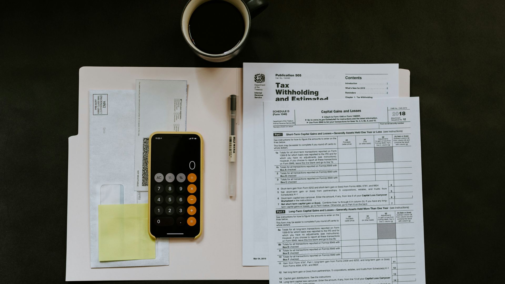 Smartphone and pen placed on tax documents in a folder