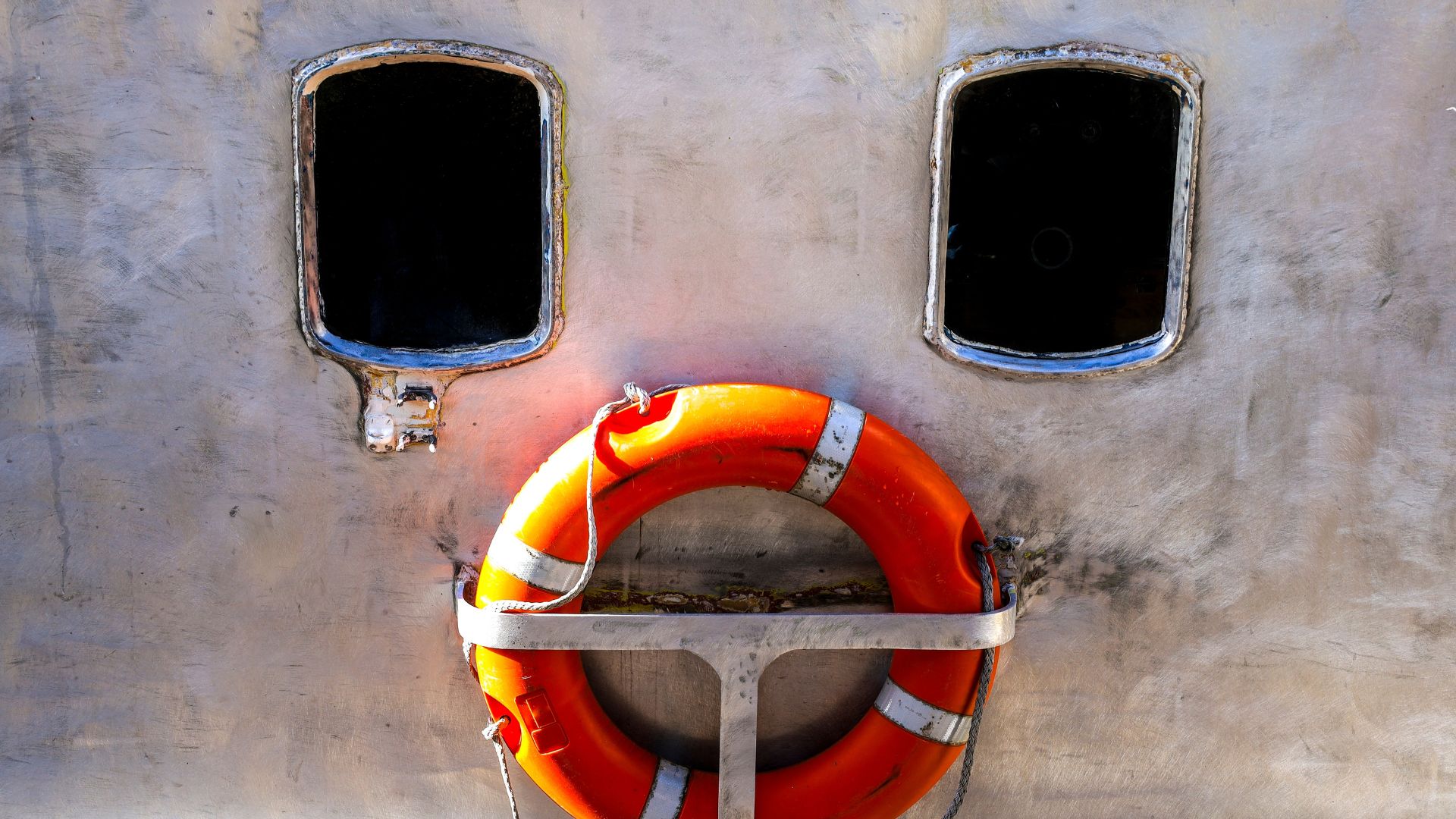 Orange lifebuoy shaped like a face through window reflection