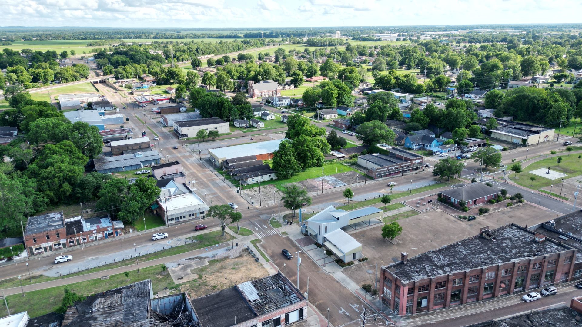 Street view of downtown Greenwood, Mississippi with shops and cars