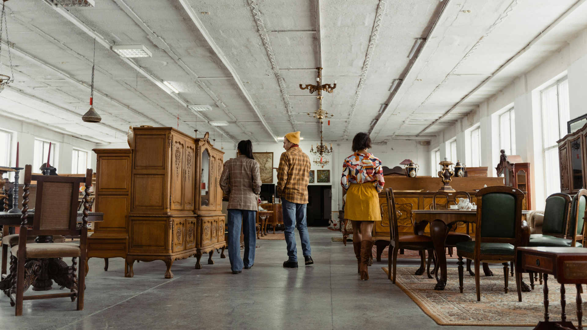Three people discussing furniture options in a showroom