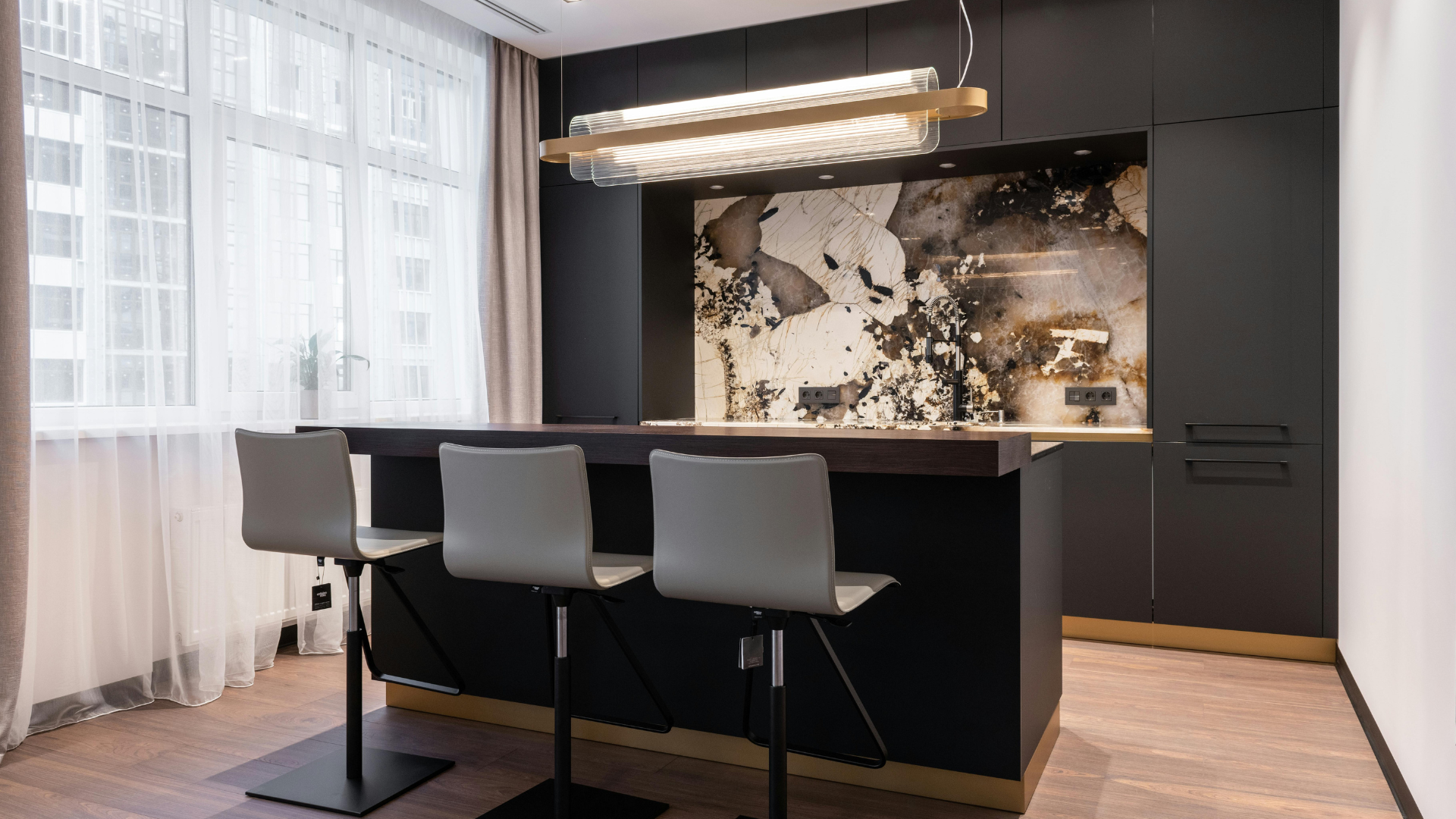 Sleek black kitchen with matte finishes and pendant lighting