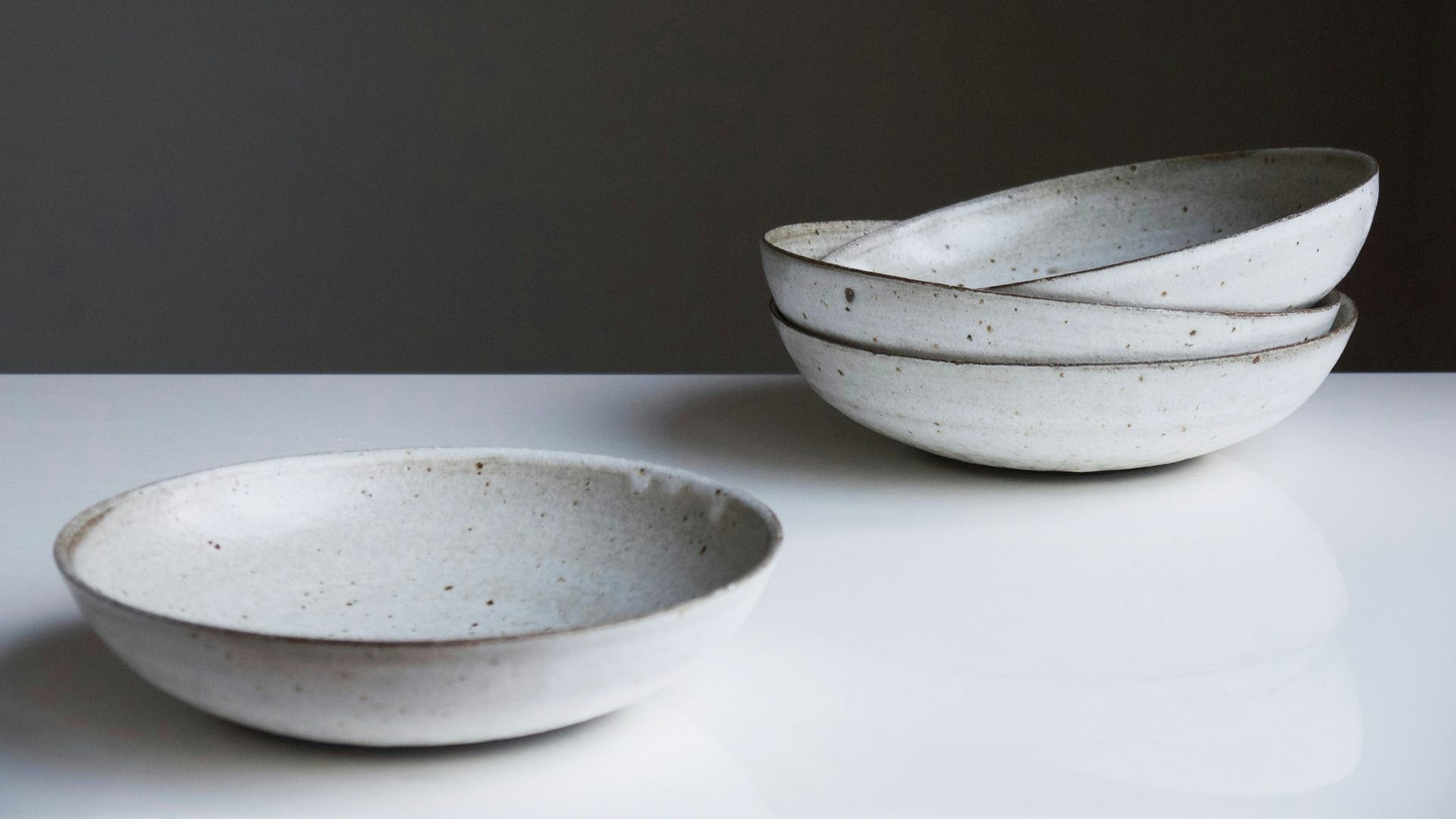 Four round white ceramic bowls on a white surface