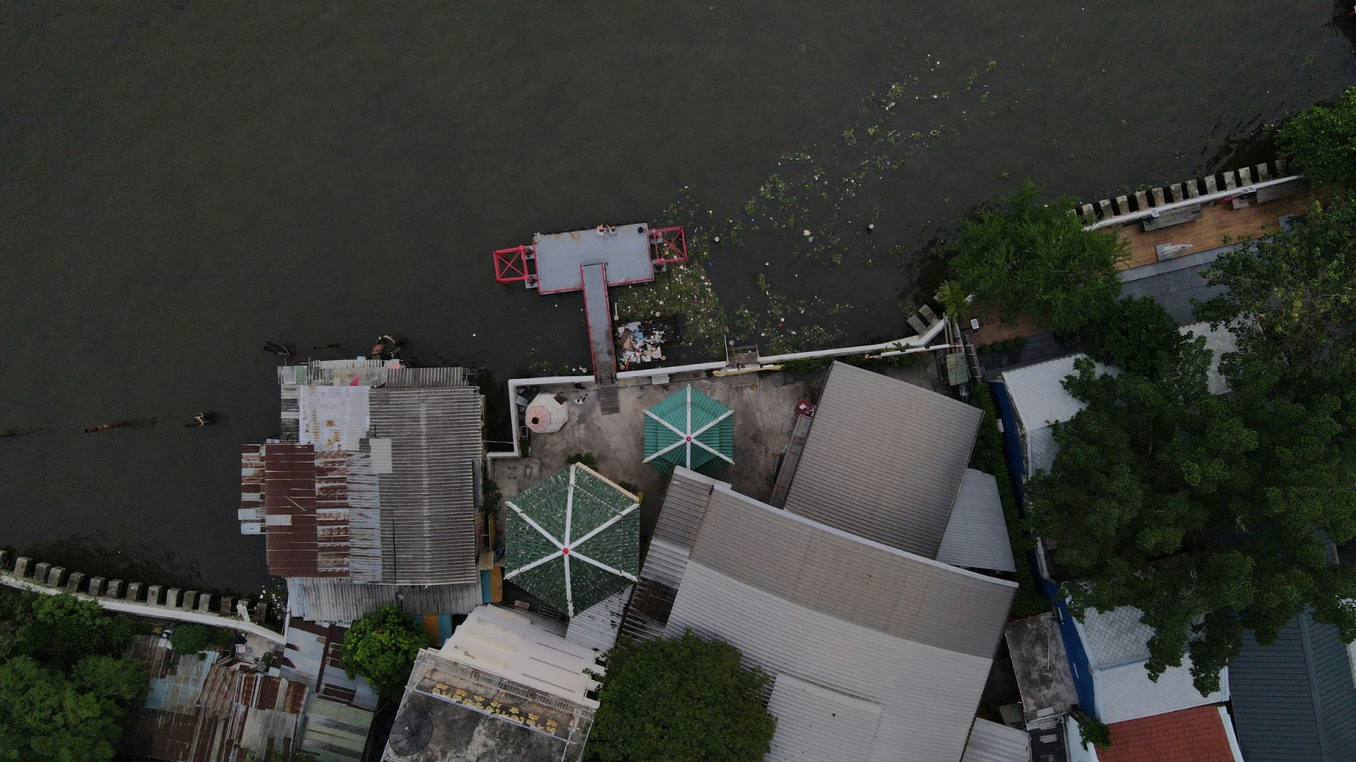 Damaged building standing near rising floodwaters