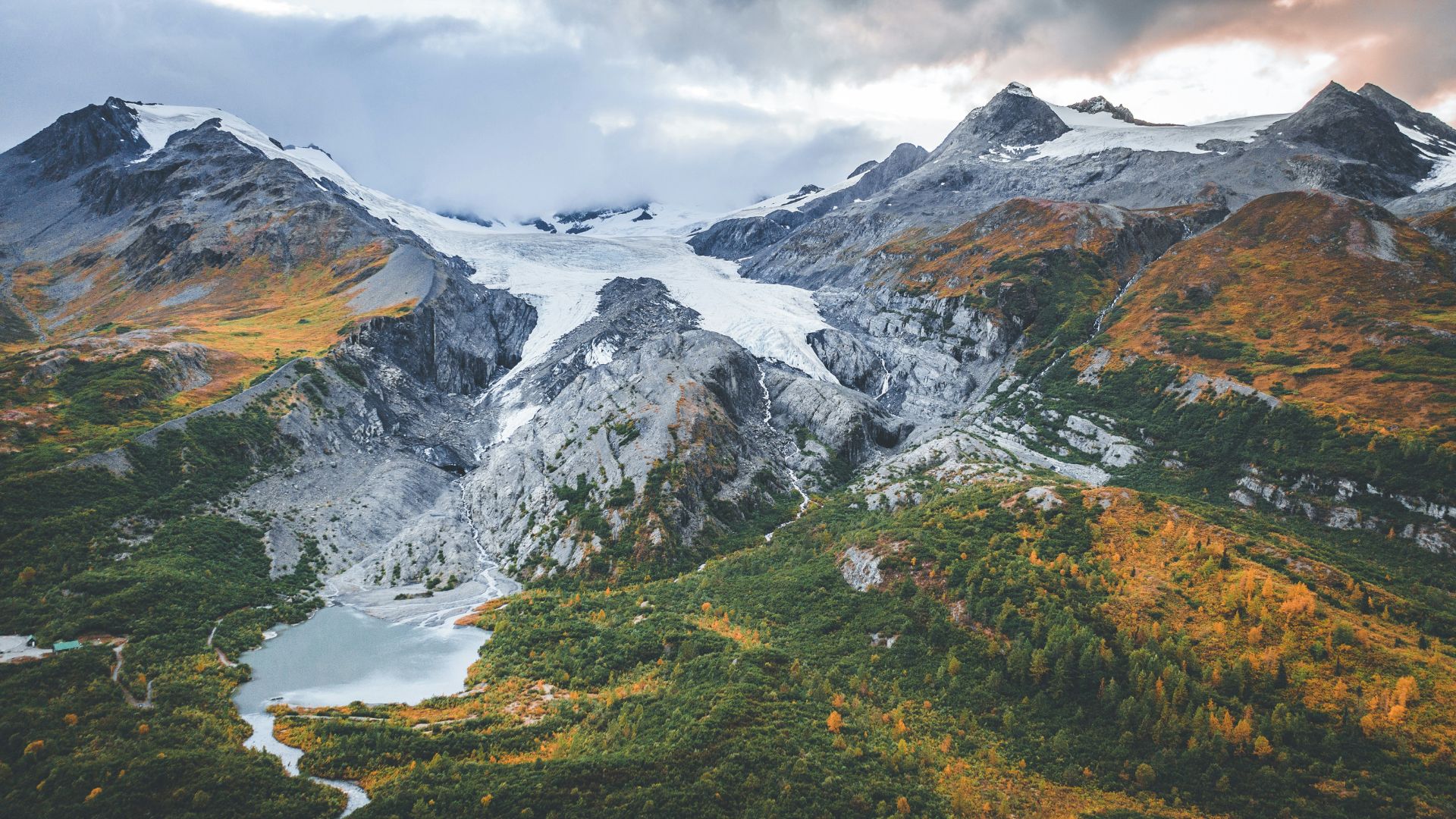 Snow-covered mountain range with a lake at its base