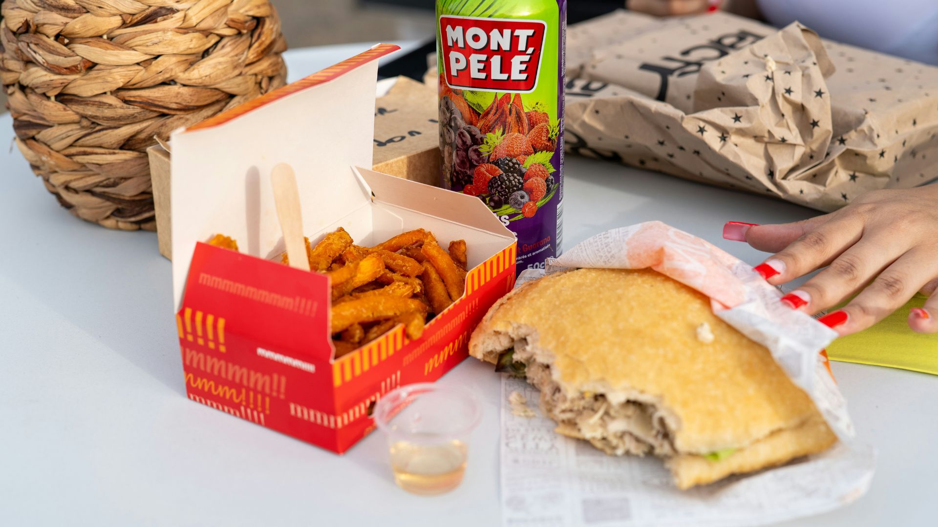 Half-eaten sandwich and soda can on a school lunch table