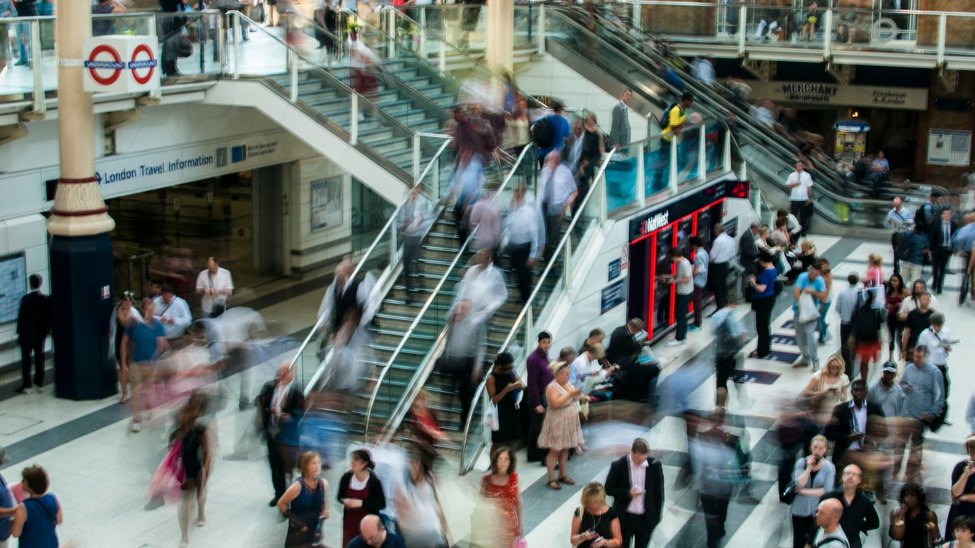 Shoppers walking on stairs inside a busy shopping mall