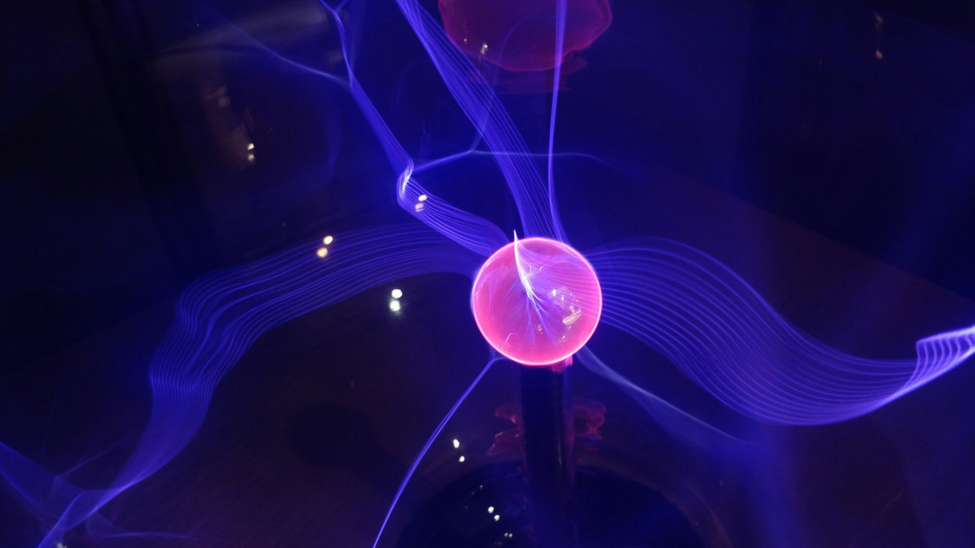 Digital visualization of a glowing red sphere surrounded by a purple aura, representing quantum energy.