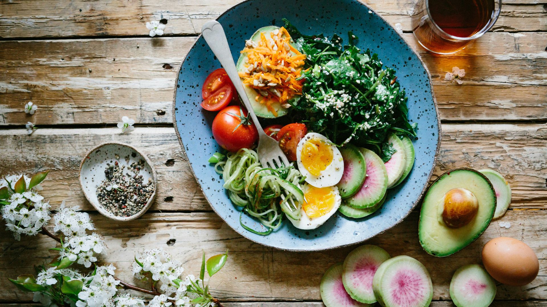 Poached egg served with vegetables and tomatoes on a blue plate