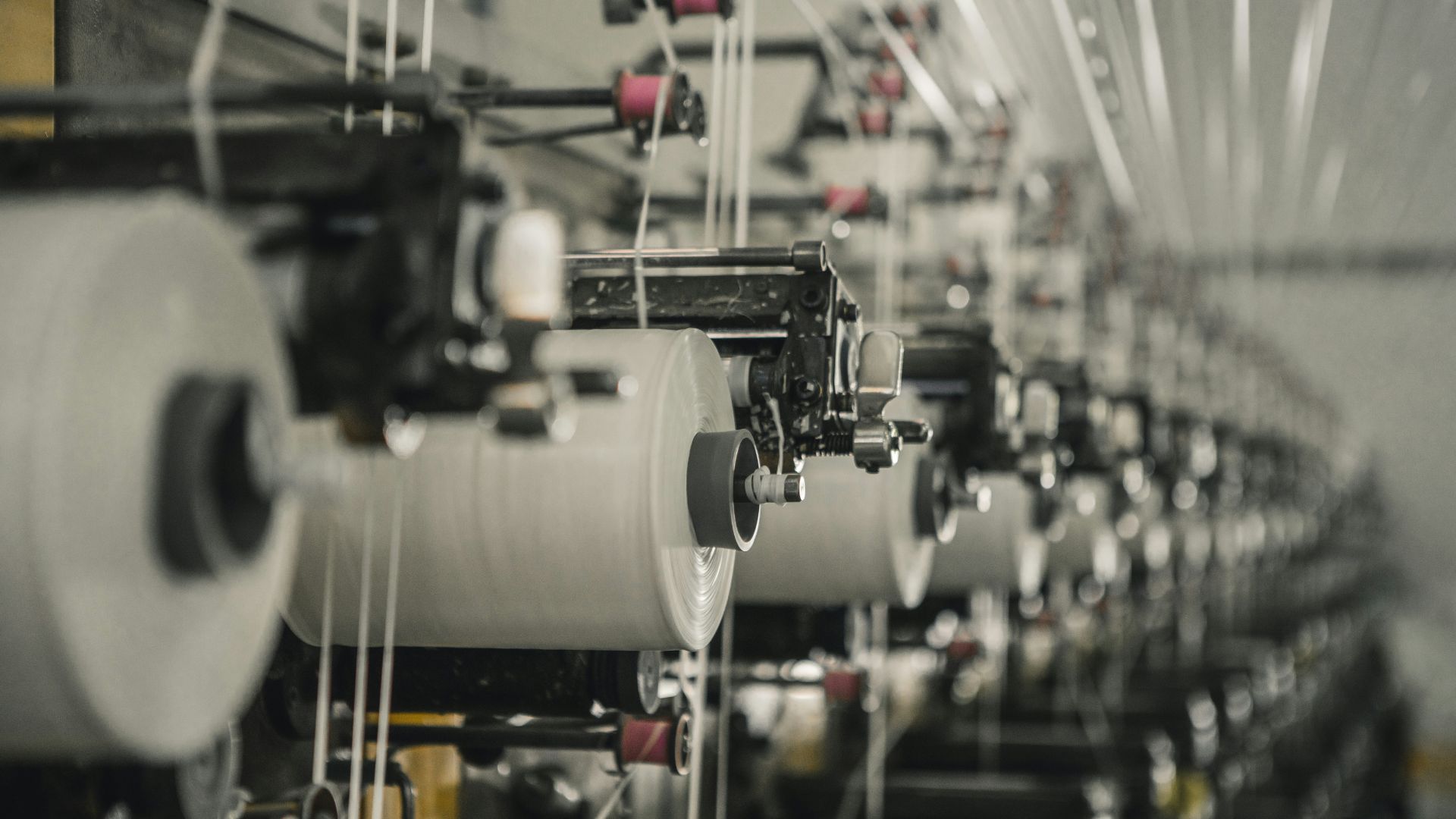 ows of textile machines standing idle inside a quiet factory