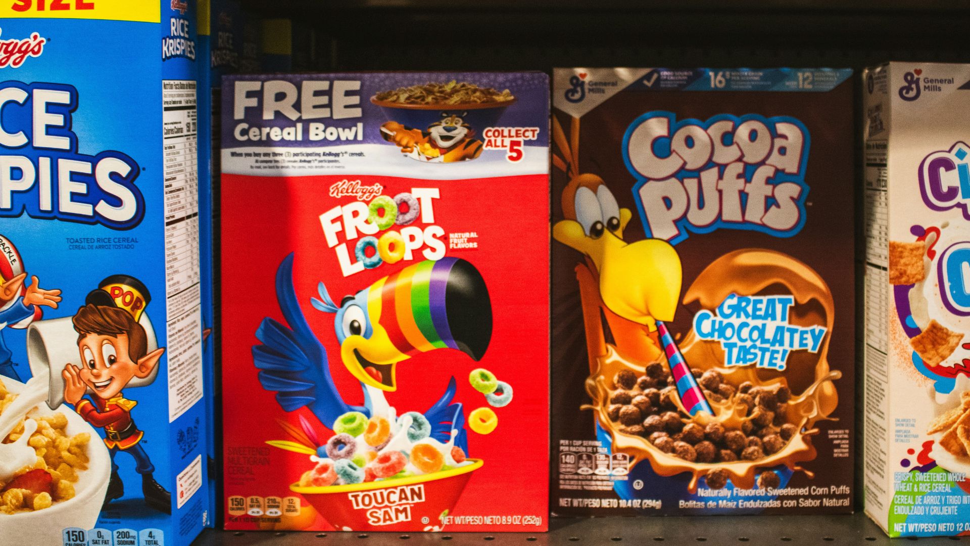 Boxes of colorful breakfast cereals displayed on grocery store shelves