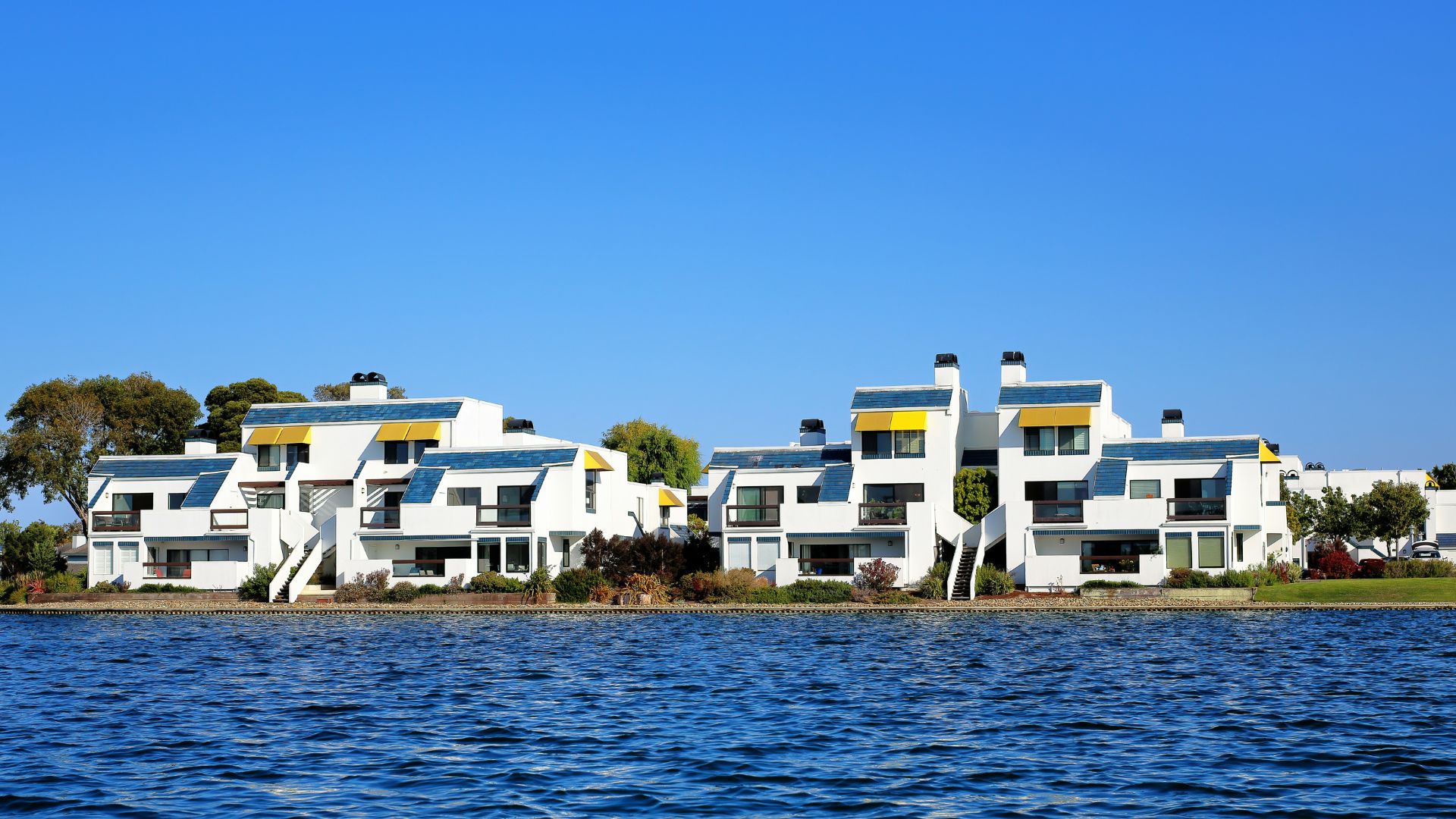 White apartment buildings near a waterfront on a clear day
