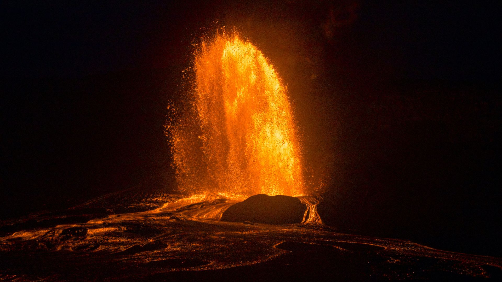 Lava erupting from a volcano under a dark sky representing tectonic activity on Earth