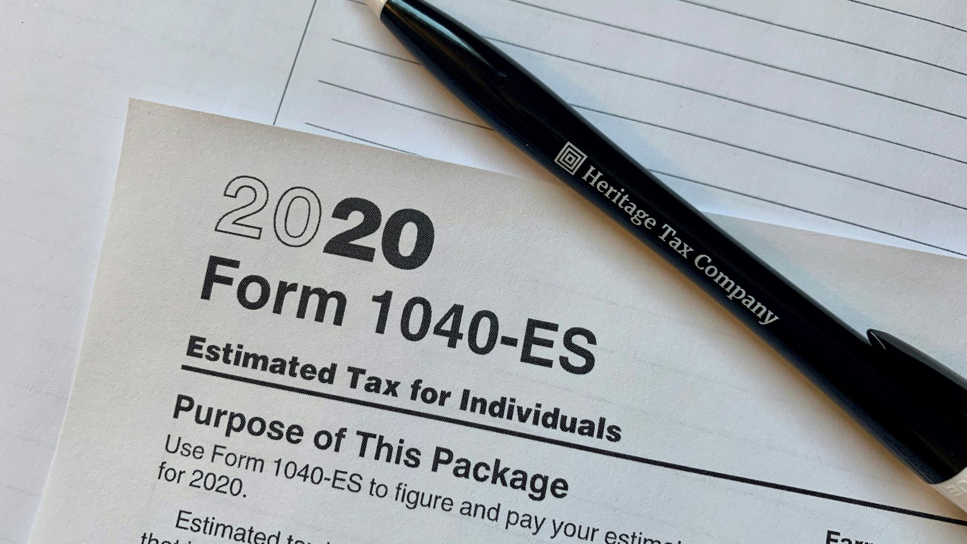Pen resting on a tax form with financial documents nearby