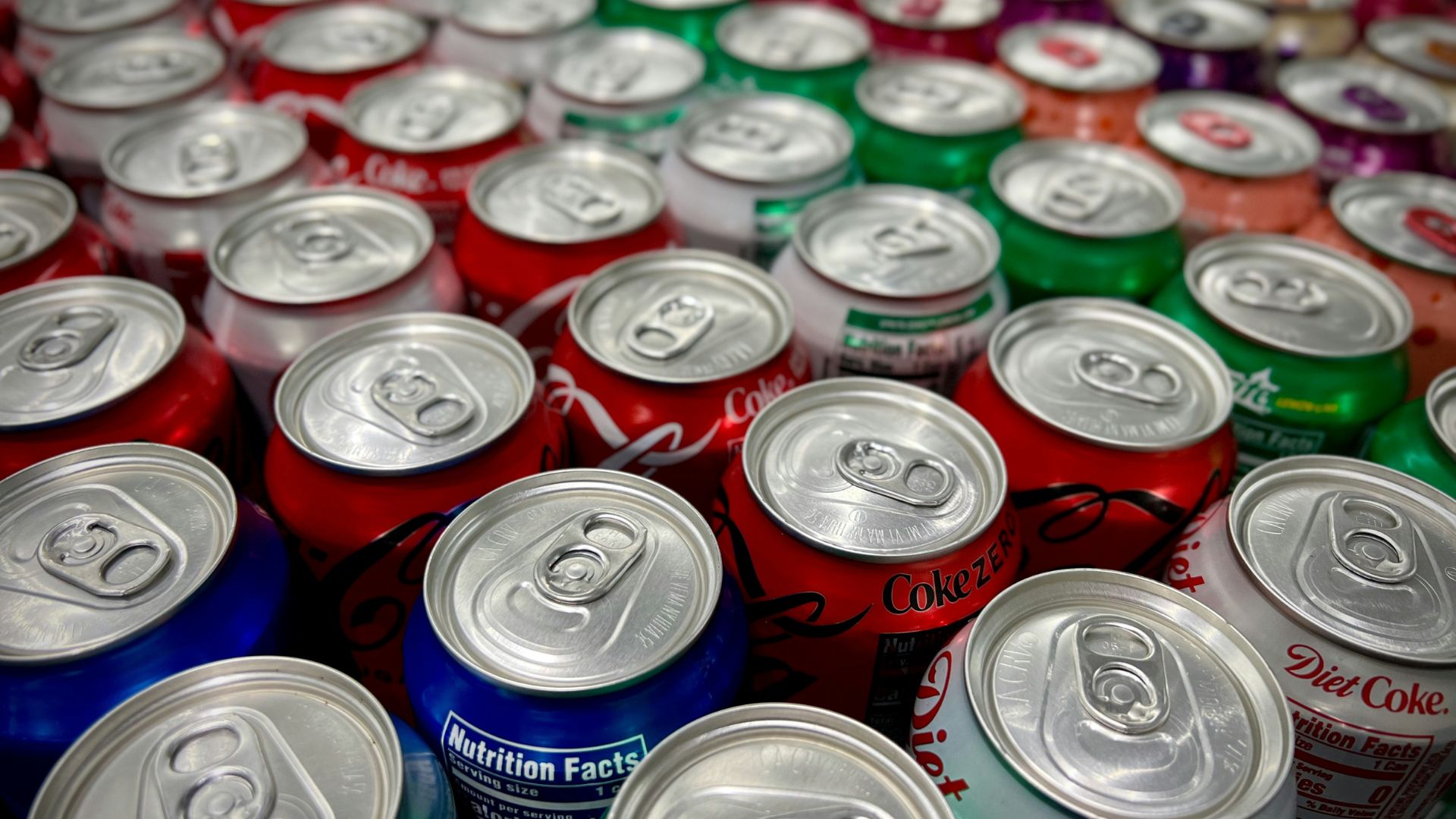Close-up of stacked soda cans in various bright colors