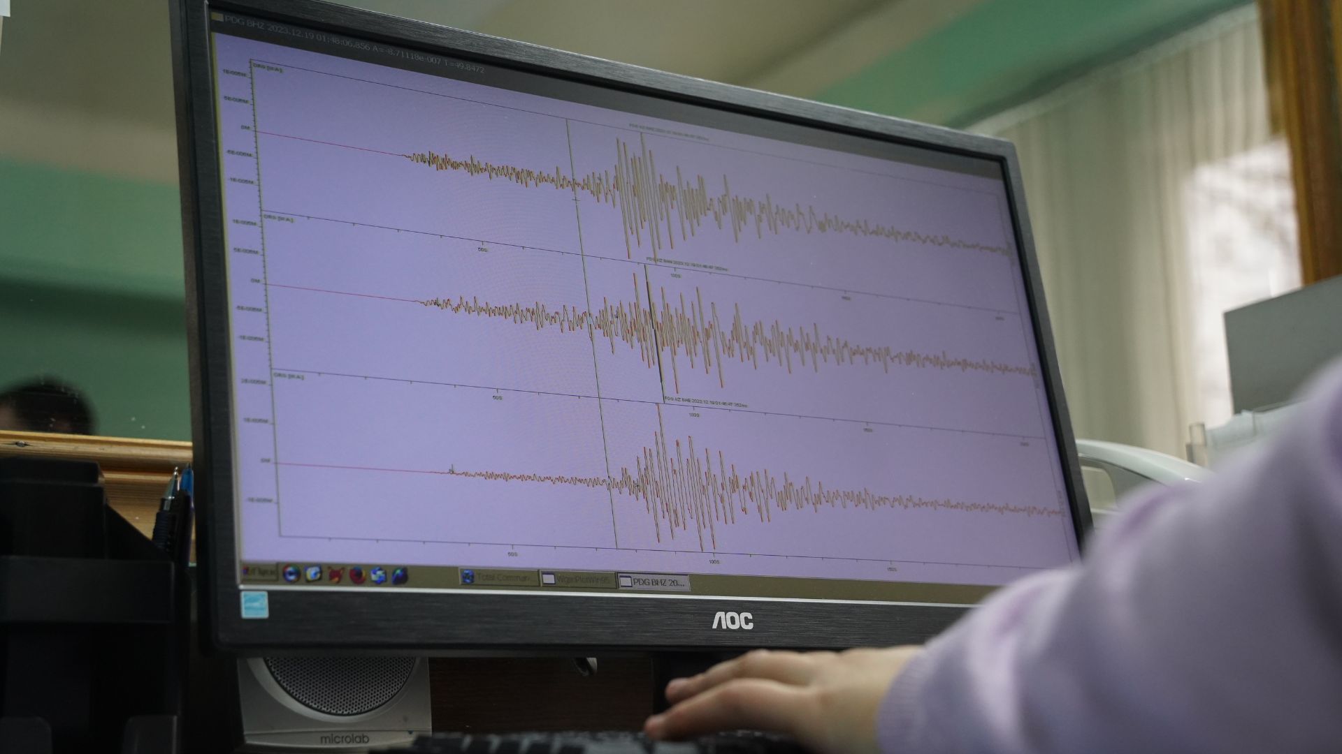 Seismograph monitor showing earthquake wave readings in a lab