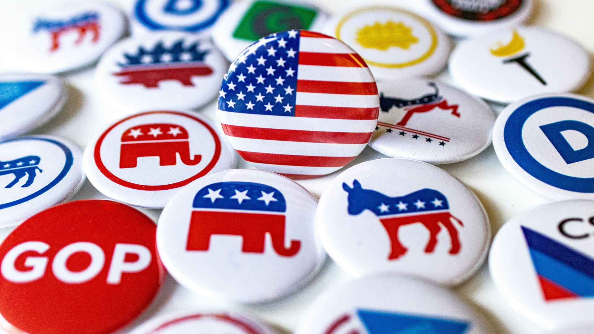 Table covered with U.S. political campaign buttons in red, white, and blue