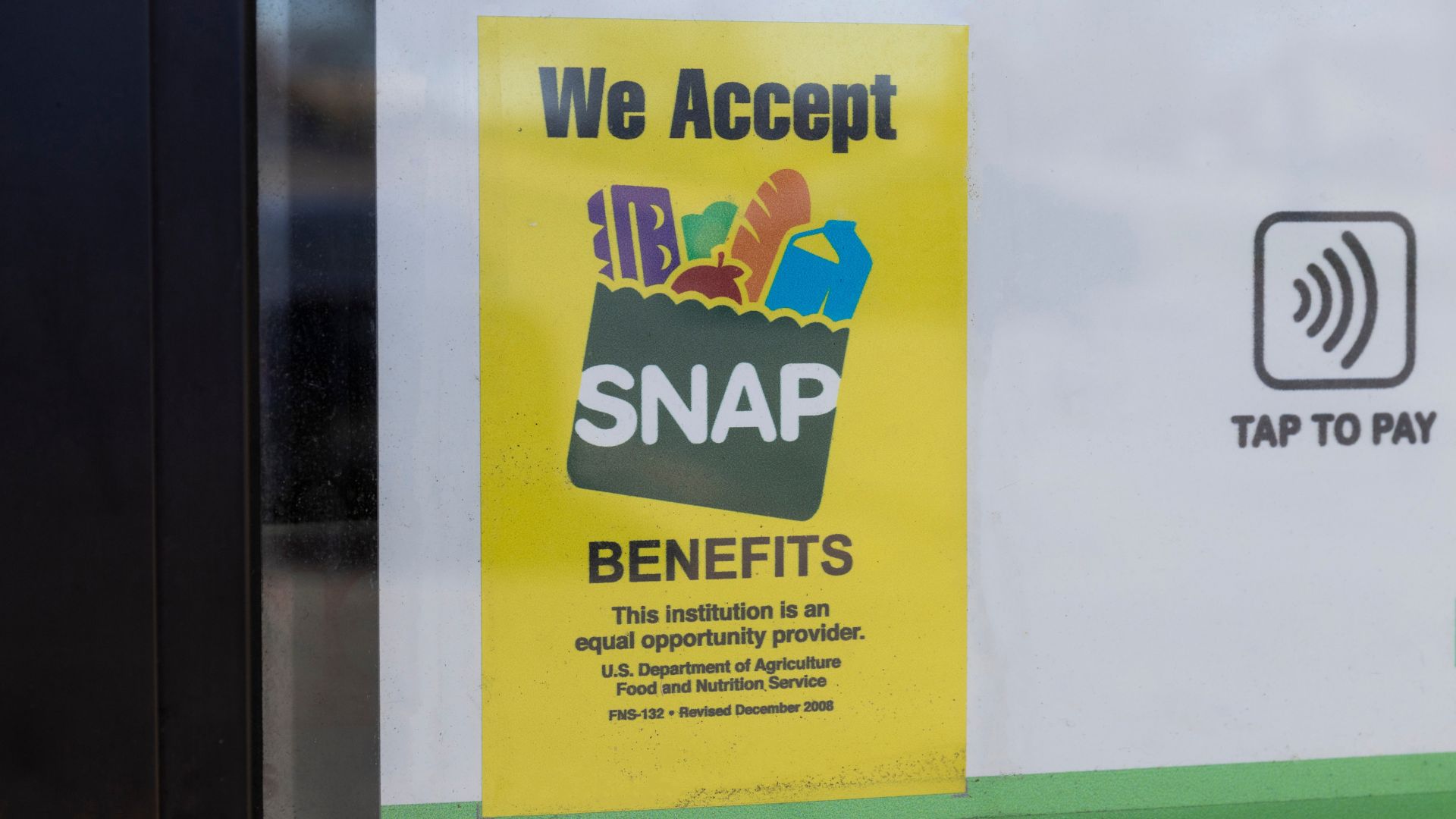 SNAP EBT card being swiped at a grocery store payment terminal in Los Angeles