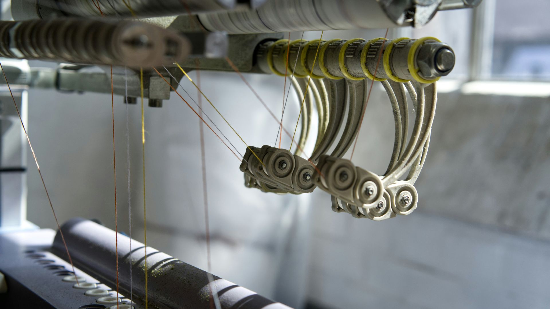 Automated textile machine weaving patterned fabric in a factory
