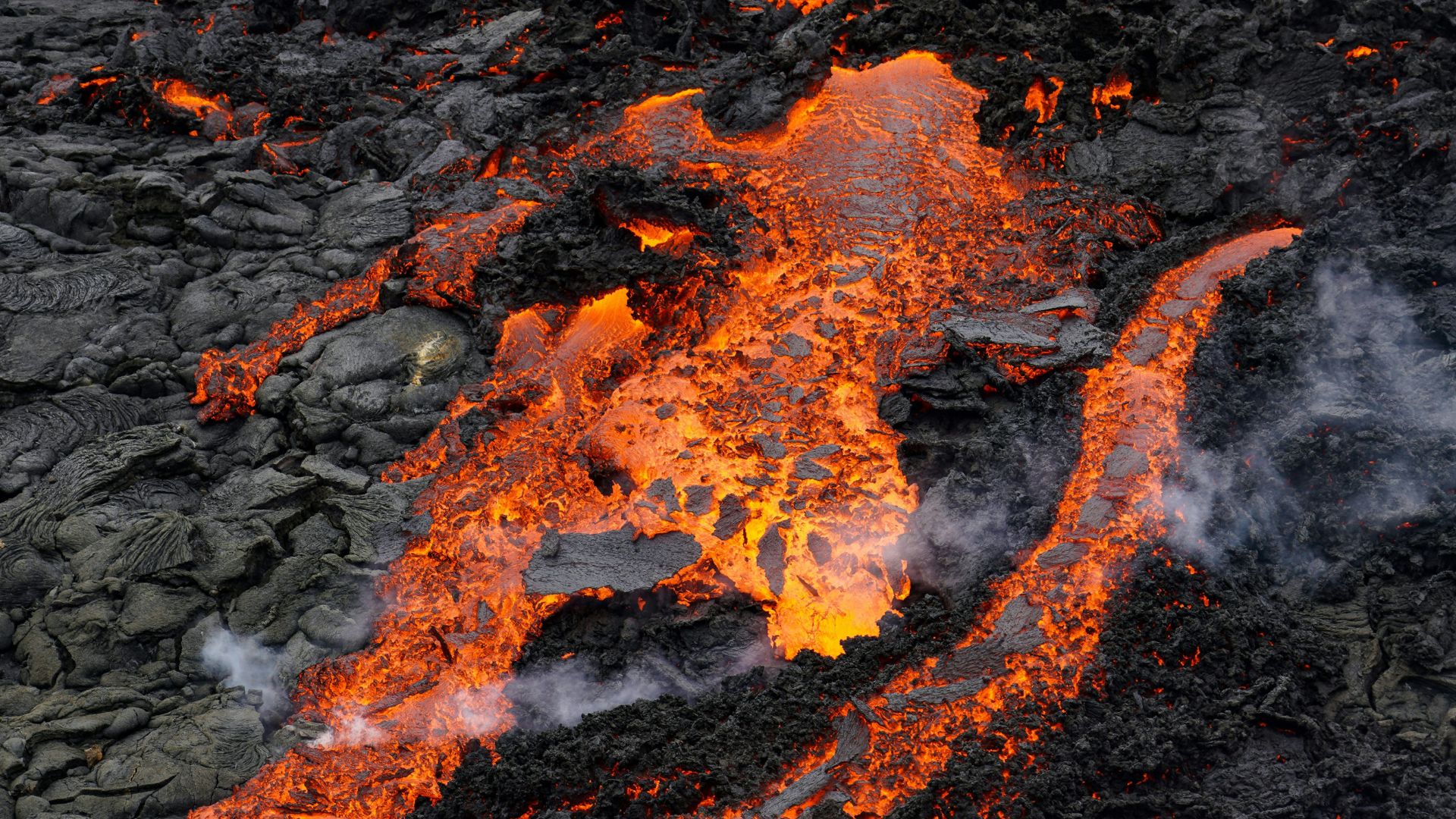 Flowing molten lava glowing red and orange illustrating magma rising through a planet’s crust