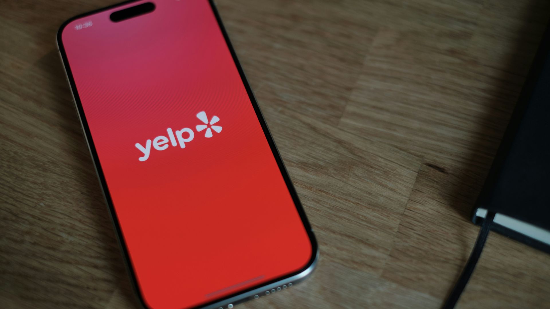 Smartphone resting on a wooden table showing online reviews