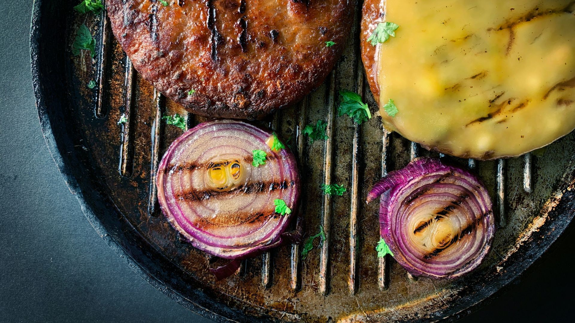Fried plant-based meat served with sliced cucumber on a black plate