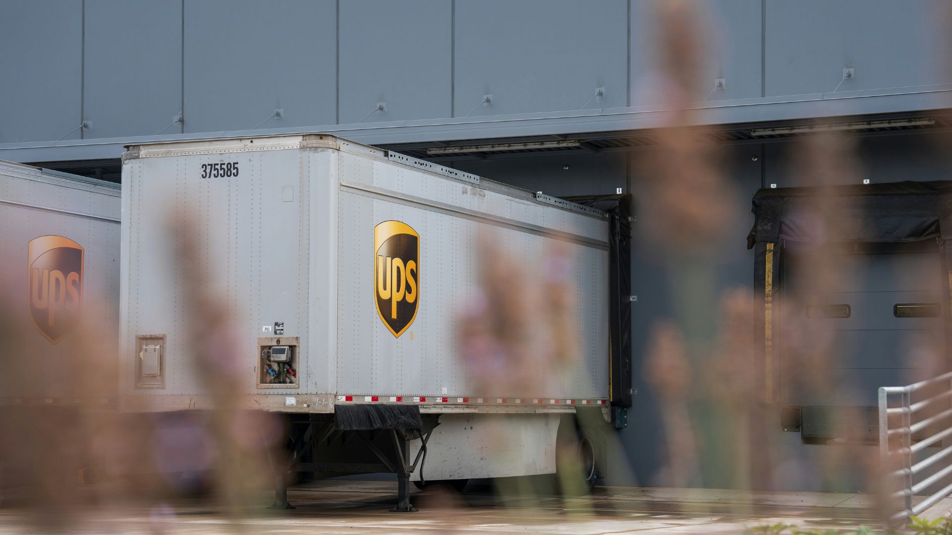 Delivery truck parked outside a large warehouse building