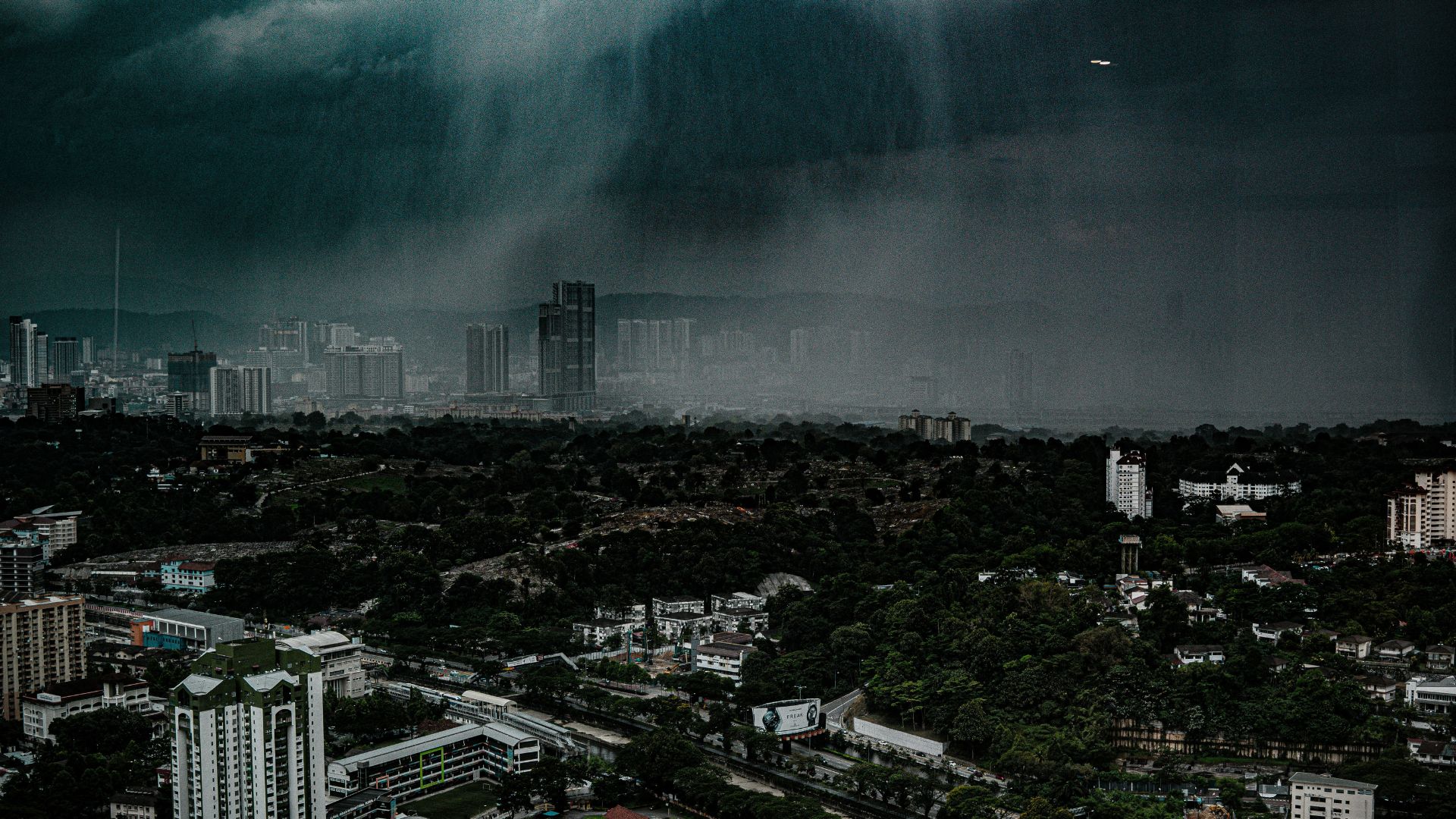 Large storm system approaching a city skyline under dark clouds