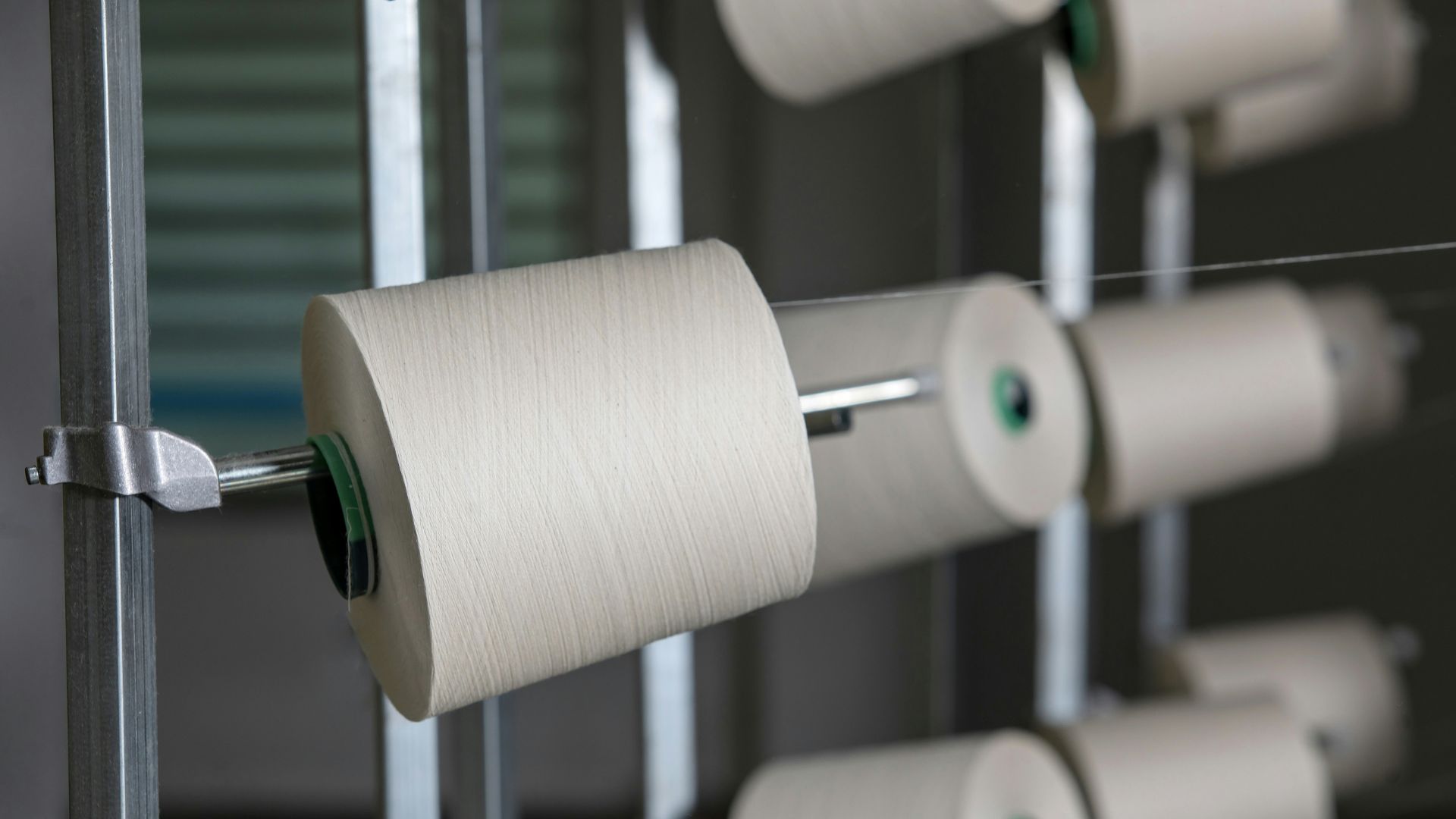 White rolls of paper on metal holders inside a clean production space
