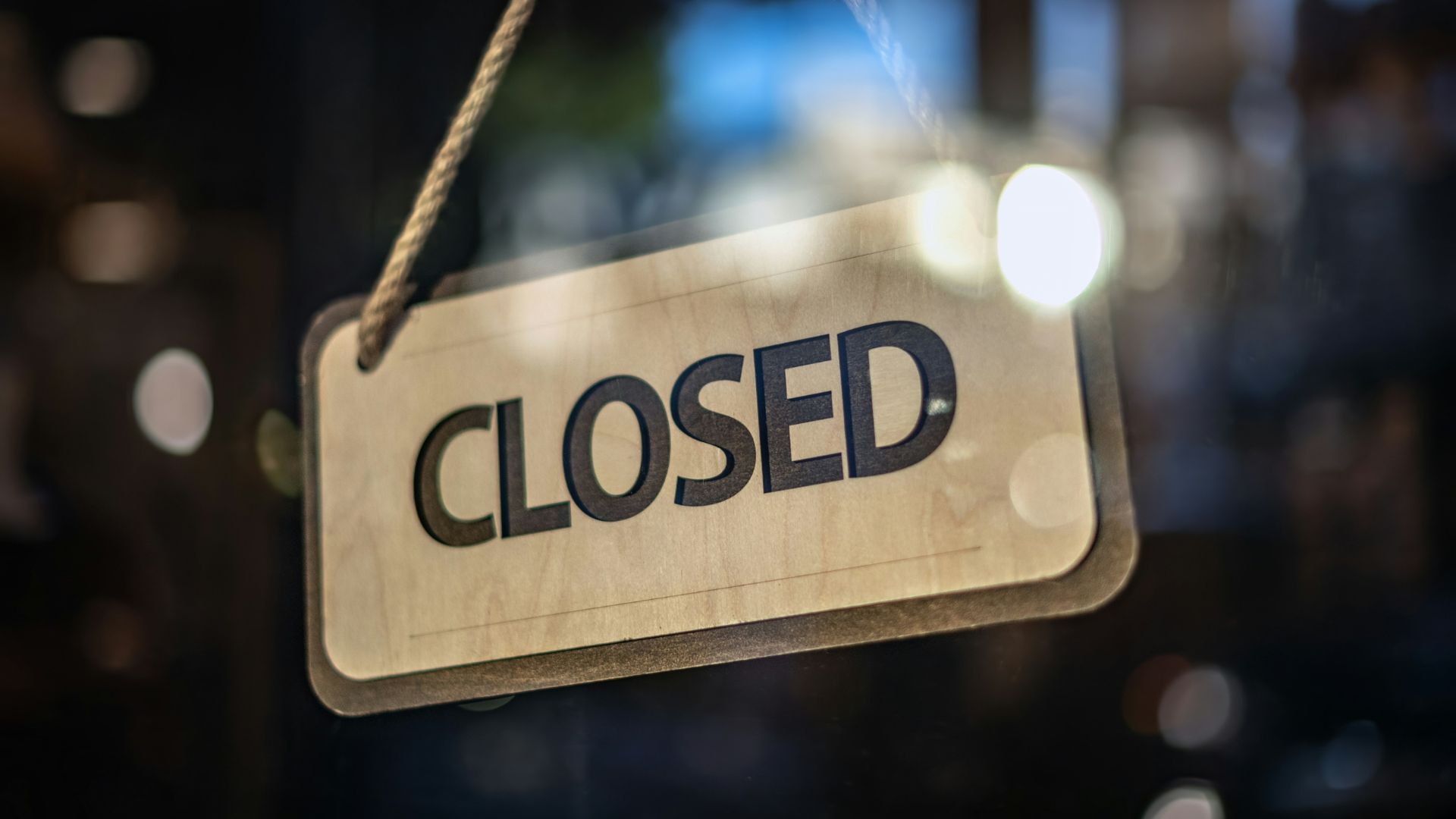 Closed sign hanging on a glass door of a storefront