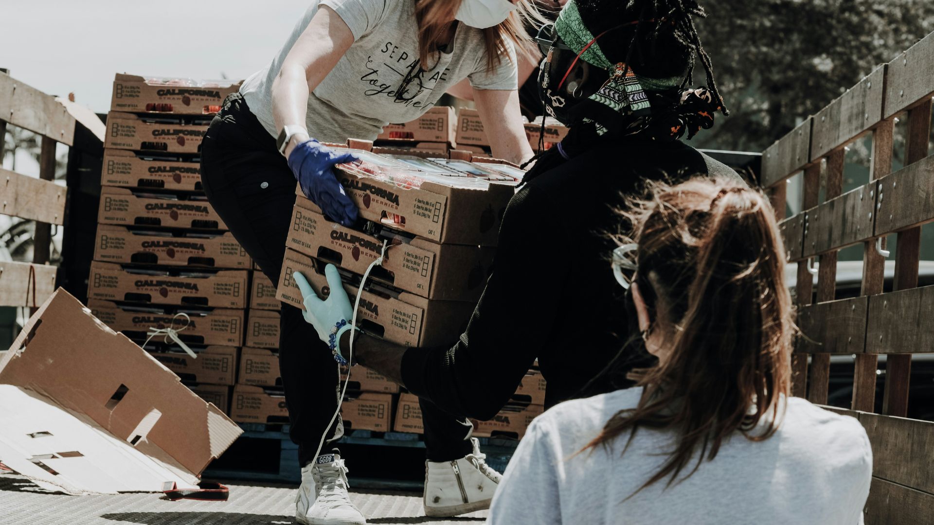 Woman sitting on a cardboard box in a room filled with moving boxes