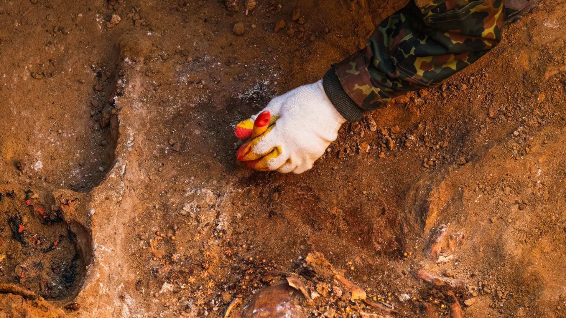 Archaeological team working around ancient tombs with exposed human remains